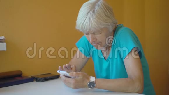 客厅里使用智能手机的老年妇女视频的预览图