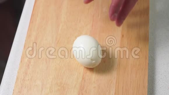 切煮鸡蛋男手在木切割板上切煮鸡蛋一把大刀视频的预览图