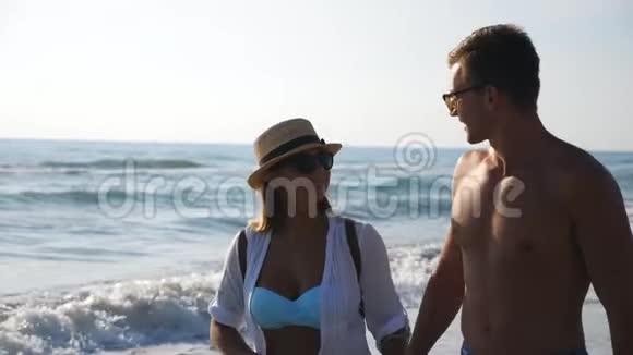 一对幸福的情侣在度假胜地休闲时在海滨散步男人拥抱女人漫步在海滩上享受视频的预览图