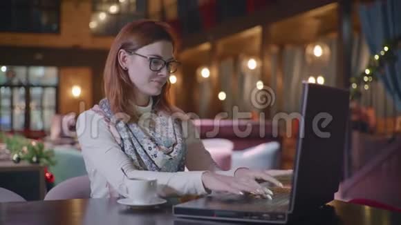戴着眼镜的年轻漂亮少女少女的肖像正在与社交网络上的朋友聊天视频的预览图