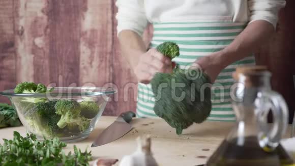 地中海美食的日常生活瞬间一位年轻的厨师将花椰菜分开放在一个玻璃碗里视频的预览图