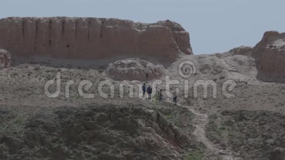 游客在沙漠中观赏古城遗址考古发掘视频的预览图