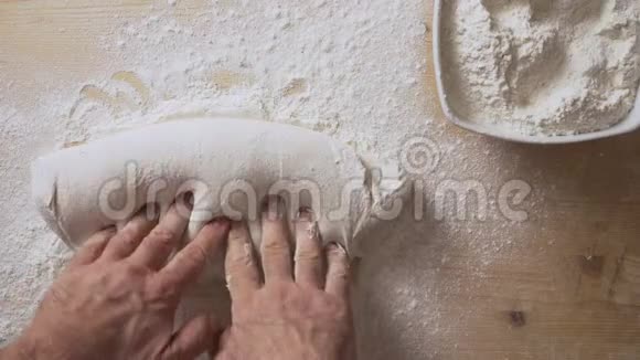 慢动作的人手按摩比萨饼面团准备它在家里发酵在一个轻木板与白色视频的预览图