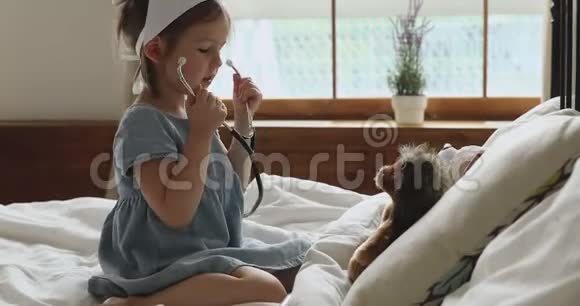 学龄前女孩假装医生在卧室治疗玩具病人视频的预览图