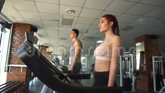 健身男女在跑步机上行走视频的预览图