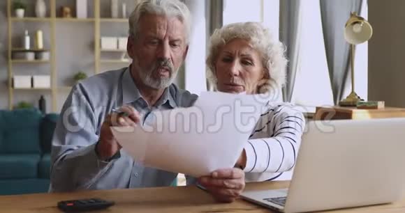 担心的老夫妇核对账单讨论未缴债务税视频的预览图