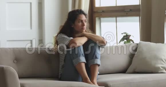 有思想的忧心忡忡的年轻女子坐在沙发上有问题视频的预览图