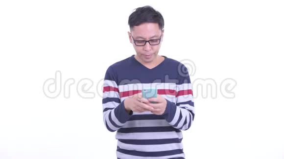 使用电话和出租车的快乐日本时髦男人的侧写视图视频的预览图