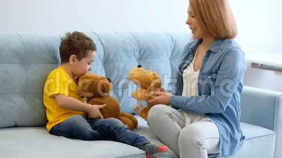 母子俩在沙发上玩玩具一起玩得开心妈妈正试图与她的多动症儿子取得联系视频的预览图