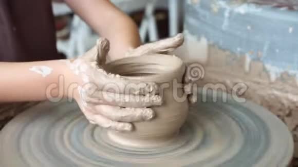 创造了一个陶罐波特粘土作坊装置上的粘土手在陶轮上工作塑造一个陶罐视频的预览图