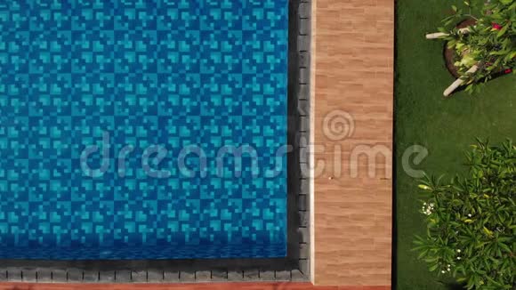 空中蓝色游泳池有水晶般清澈的水在阳光下俯视水面有波纹视频的预览图