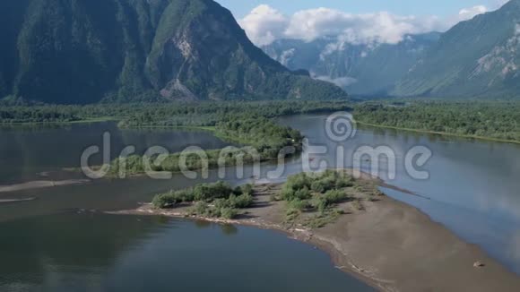 在4k山的背景下飞越一条流入湖泊的河流视频的预览图