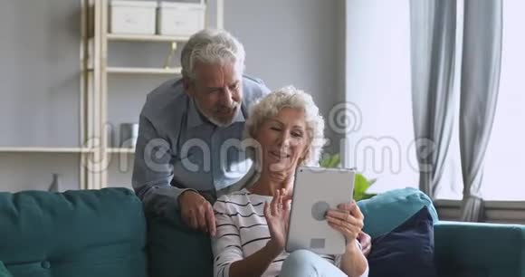 一对老夫妇在家里用平板电脑聊天视频的预览图
