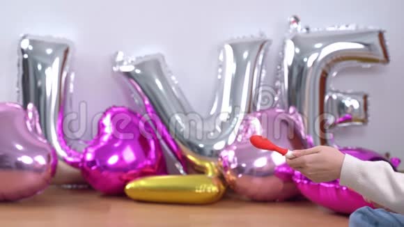 女人是手动抽水成型气球准备派对装饰在家里近距离4K生活方式视频的预览图
