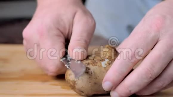 一个男人把煮熟的土豆从皮肤上清洗视频的预览图