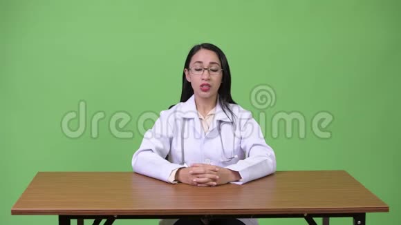 年轻漂亮的亚洲女医生对着镜头说话视频的预览图