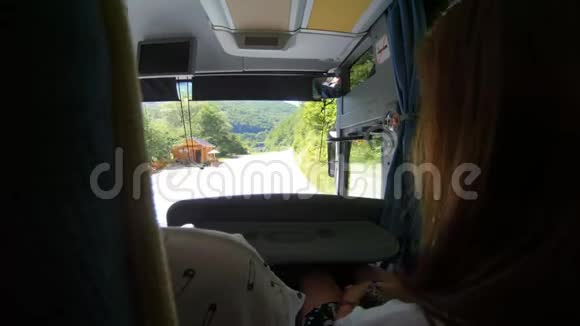 从巴士上可以看到旅游巴士人们游览乡村道路美丽的自然背景视频的预览图