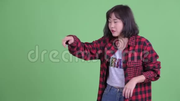 快乐的亚洲时髦女人摸东西跳舞视频的预览图