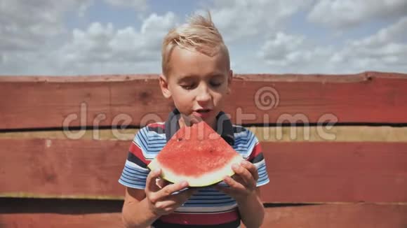 一个男孩在晴天吃西瓜视频的预览图