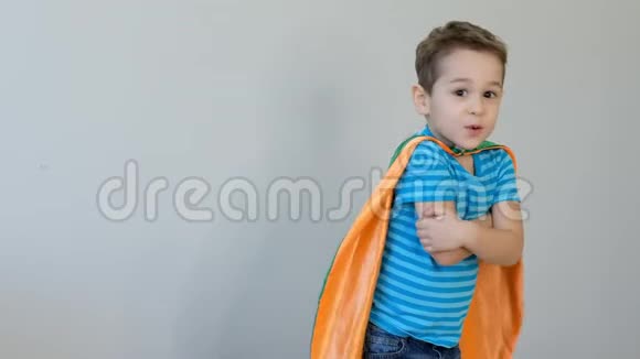 一个穿着超级英雄服装的男孩用手拥抱自己的肖像成功的概念快乐的童年4k视频视频的预览图