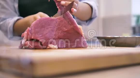 女厨师在厨房里切了一大块鲜肉视频的预览图