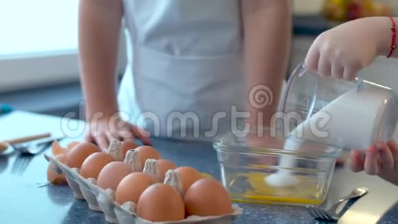 孩子的手把糖倒进玻璃碗里视频的预览图