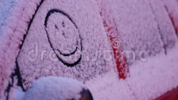 欢快的表情被涂在汽车玻璃上的新鲜雪上微笑快乐的脸视频的预览图