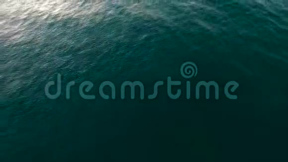 在平静的海洋水面上随着阳光的反射海浪缓慢移动视频的预览图