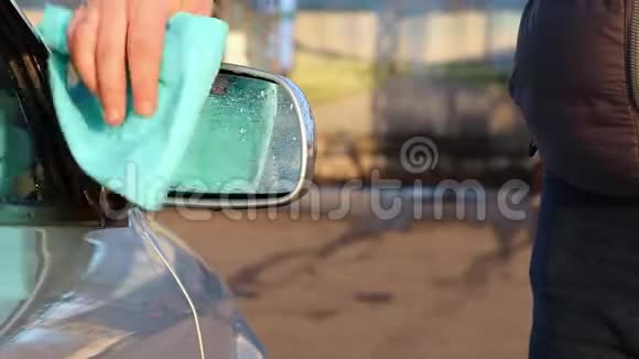 一个男人用超细纤维擦拭车内的侧镜汽车护理概念视频的预览图
