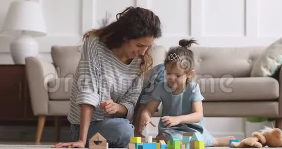 可爱的小女孩和妈妈笑着玩木块视频的预览图