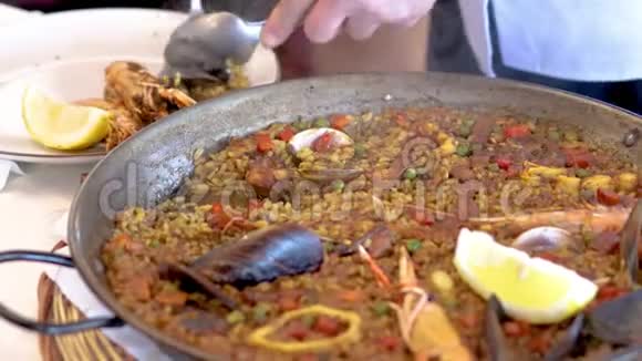 一名服务员在西班牙餐厅供应传统的地中海海鲜饭视频的预览图