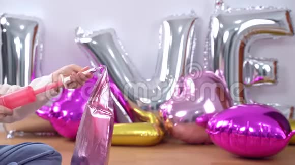 女人是手动抽水成型气球准备派对装饰在家里近距离4K生活方式视频的预览图
