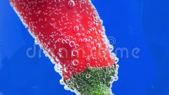 意大利辣香肠的红色胡椒特写浸入水中并被气泡包围用于烹饪选择性聚焦视频的预览图