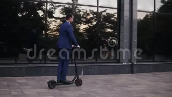 年轻的商人骑着电动滑板车在办公室办公楼里开商务会议商人视频的预览图
