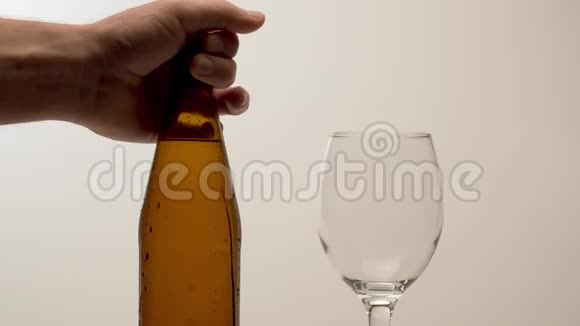 男人的手在桌子上放一瓶雾状的啤酒视频的预览图