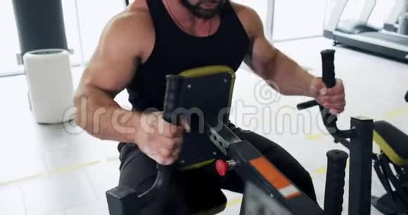在体育俱乐部运动模拟器上锻炼肌肉现代健身机上运动的男运动员视频的预览图