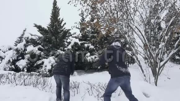 在冬天降雪的时候男人会慢慢地向对方扔雪男人到处乱搞乐趣和乐趣视频的预览图