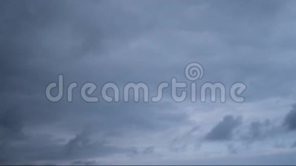 在一片戏剧性的天空中从右到左不间断地在循环中流动的灰色云的无缝时间流逝视频的预览图