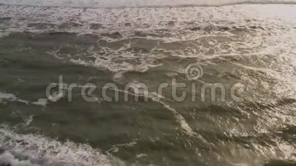 巨大的波浪从上面滚动无人机在蓝色绿松石海洋上的视野破浪粉饰乌云密布的大海视频的预览图