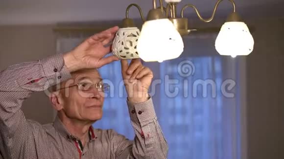 戴眼镜和衬衫的老人取代了光彩照人的最后一个灯泡视频的预览图