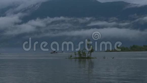 摩托艇在雾中漂浮在河上在群山的背景下视频的预览图