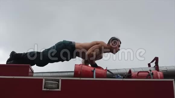 强壮的男人在消防车上做俯卧撑近景视频的预览图