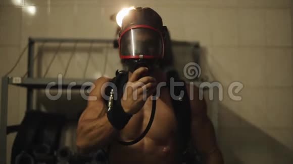 慢动作一个英俊的赤膊消防员把氧气面罩戴在脸上朝镜头走去明亮明亮视频的预览图