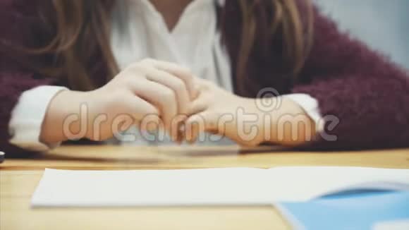 把一个女学生的手放桌子上灰色背景视频的预览图
