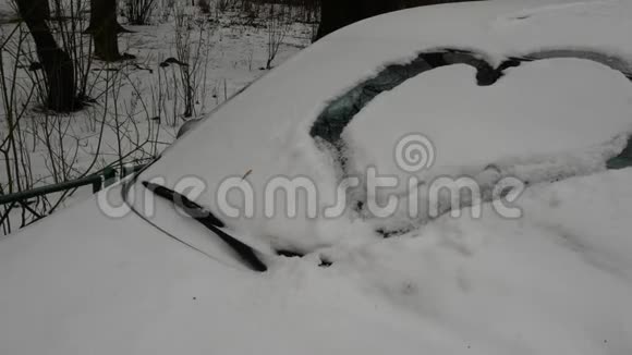 在车上雪层上画的心脏符号一辆被雪覆盖着的汽车视频的预览图