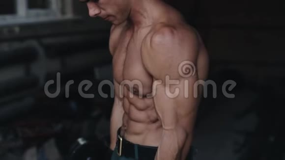 一个强壮的运动员在健身房举起杠铃的侧视图视频的预览图