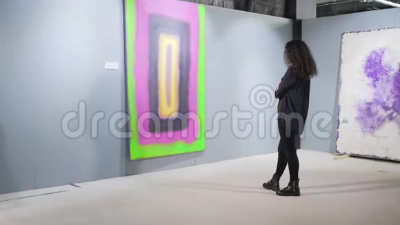 在艺术画廊里凝视着那幅画的女人视频的预览图