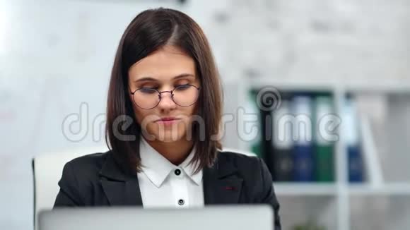 漂亮的书呆子女办公室职员簿记员在白色工作场所看电脑屏幕视频的预览图