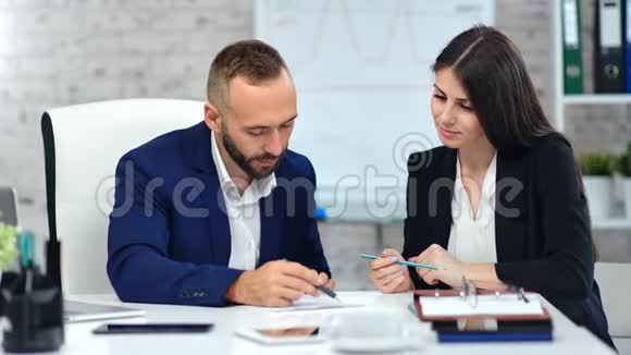 男老板用钢笔在纸上签合同看工作场所的数据视频的预览图