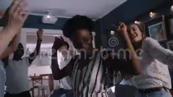 快乐的年轻微笑迷人的非洲妇女与朋友在一个多民族的节日庆祝聚会上跳舞视频的预览图